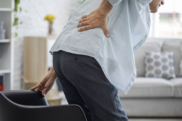 Senior man experiencing back pain, in need of chiropractic treatment.